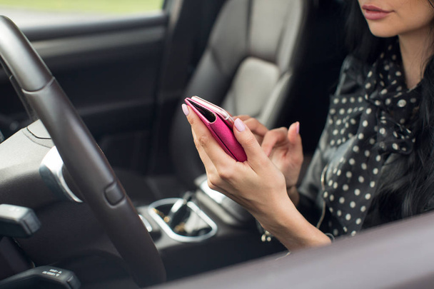 woman using smartphone. Blurred car interior - Фото, изображение