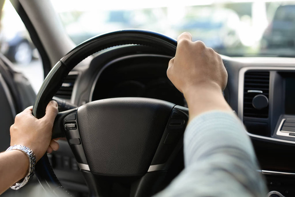 Male hands on steering wheel of a car - Foto, imagen
