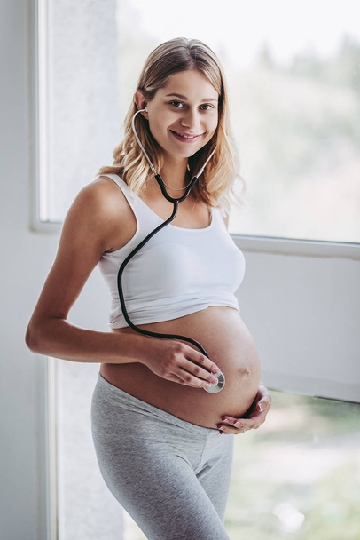 Pregnant woman at home - Foto, afbeelding