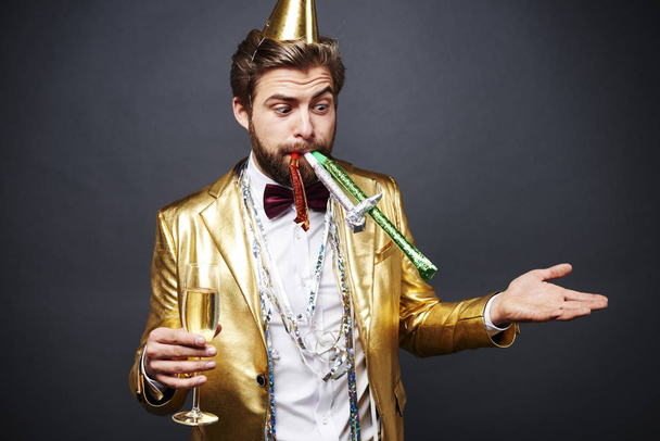 Homme étonné avec ventilateur de fête debout avec flûte à champagne
 - Photo, image