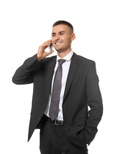 Handsome young businessman talking on mobile phone against white background - Fotoğraf, Görsel