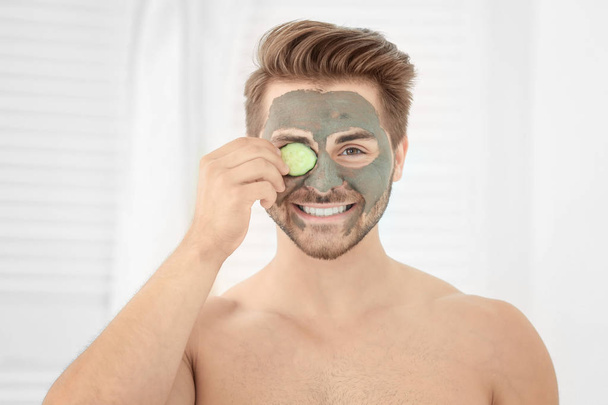 Young man with cosmetic mask on his face in bathroom - Foto, Imagem