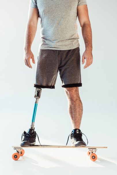 man with leg prosthesis standing on skateboard - Photo, Image