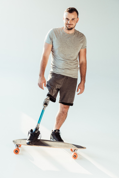 man with leg prosthesis standing on skateboard - Fotó, kép