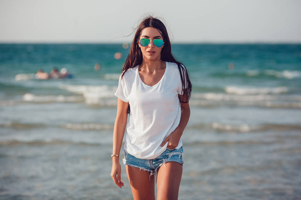 Girl in a white t-shirt on the background of the ocean. Mock-up. - Foto, afbeelding