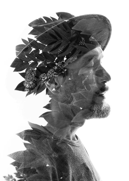 Man wearing hat combined with tree leaves - Φωτογραφία, εικόνα