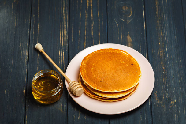 Tasty healthy breakfast - fresh pancakes with honey - 写真・画像