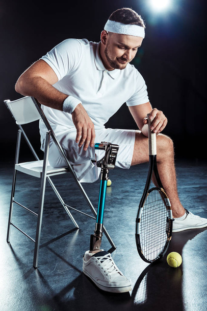 Паралимпийский теннисист отдыхает на стуле
 - Фото, изображение