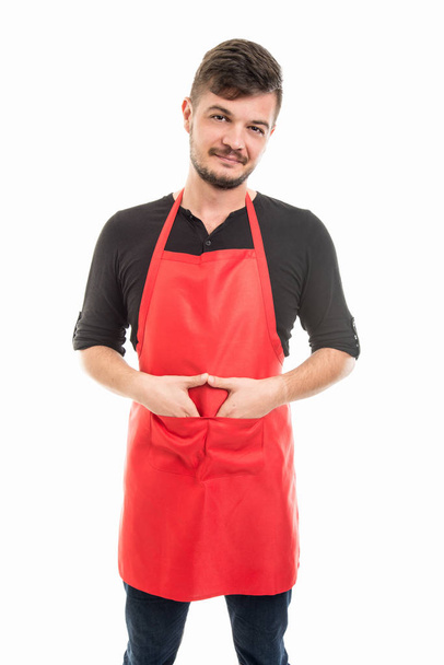 Mannelijke supermarkt werkgever permanent met handen in de zakken - Foto, afbeelding