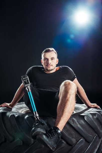 sportivo paralimpico appoggiato su pneumatico
 - Foto, immagini