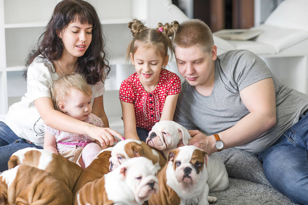 Beautiful family resting on the weekend with cute little puppies - 写真・画像