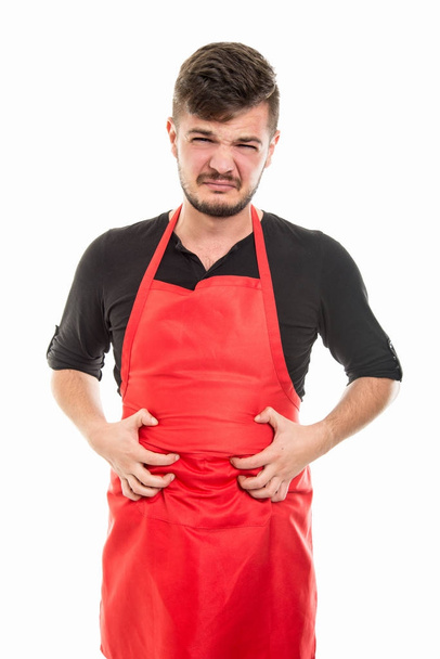 Male supermarket employer holding belly like in pain - Photo, Image