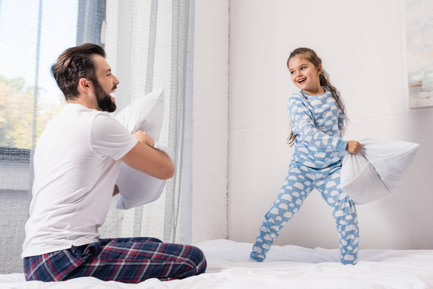 pai e filha lutando com travesseiros
 - Foto, Imagem