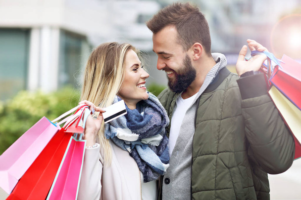 Счастливая пара делает покупки в городе
 - Фото, изображение