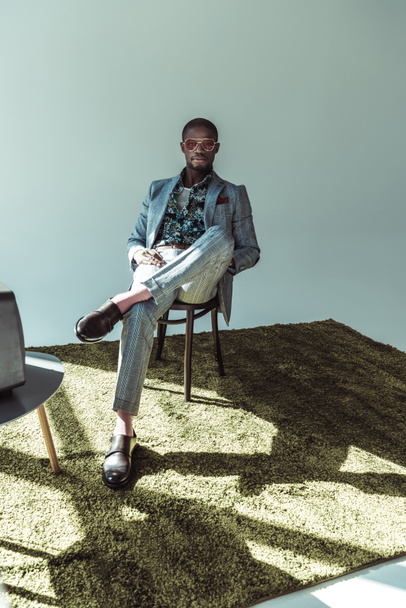 man in stylish suit posing on chair - Valokuva, kuva