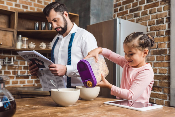 daughter pouring cereal in bowl for father - Foto, immagini