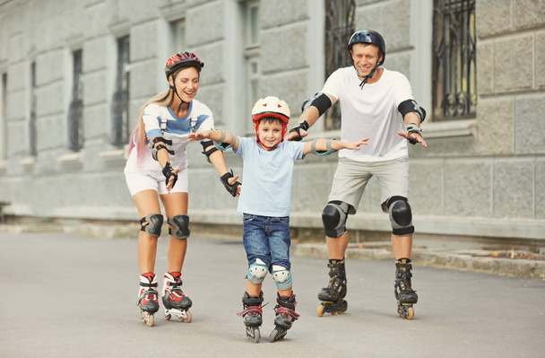 Family on roller skates outdoors - Foto, imagen