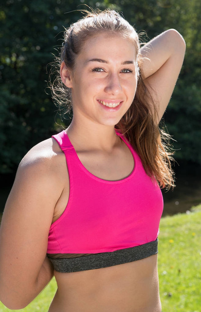 young woman sporty girl with pink top workout outdoor - Zdjęcie, obraz