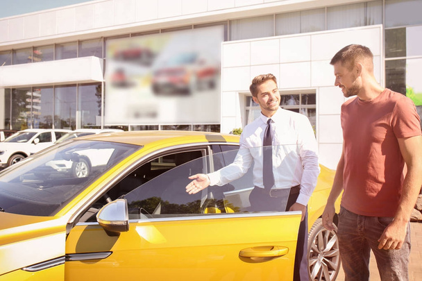 Salesman showing new car  - Zdjęcie, obraz