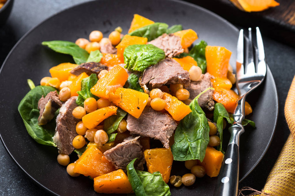Warm salad with pumpkin, baked beef, spinach and chickpeas. - Photo, Image