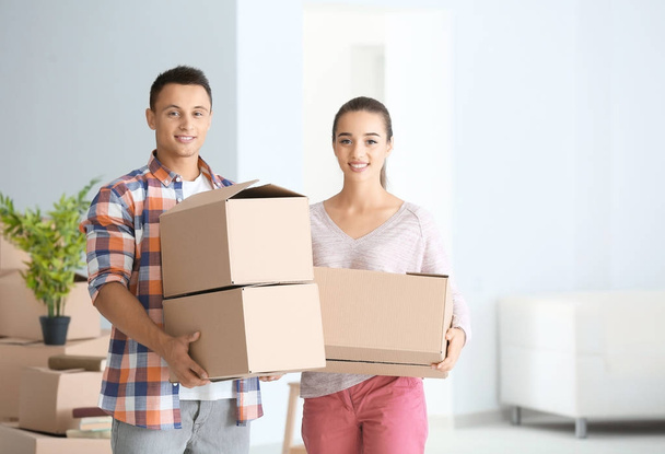 Happy young couple with moving boxes in their new apartment - Fotoğraf, Görsel