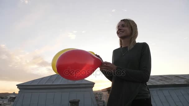 Portret szczęśliwy dziewczyna trzymając w rękach balonów i następnie puścić balony - Materiał filmowy, wideo