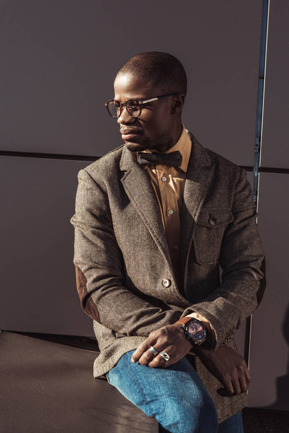 Stylish man in suit sitting on concrete - Zdjęcie, obraz