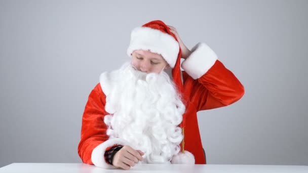 A young guy in Santa Claus costume takes off his hat 50 fps - Materiaali, video