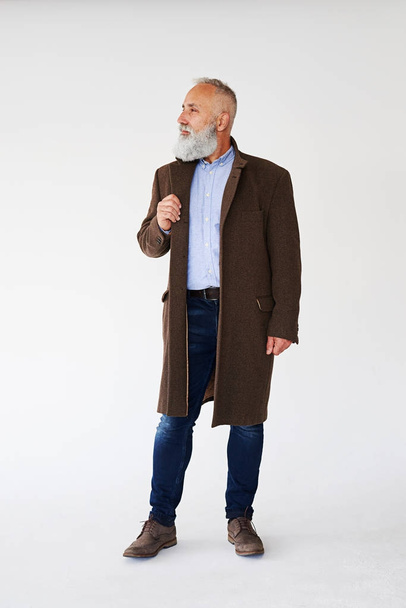 Knappe volwassen bebaarde man gekleed in herfst jas  - Foto, afbeelding