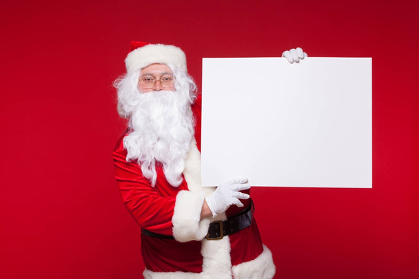 Santa Claus wijzen in lege Reclameaankondiging Vlag geïsoleerd op rode achtergrond met kopie ruimte - Foto, afbeelding