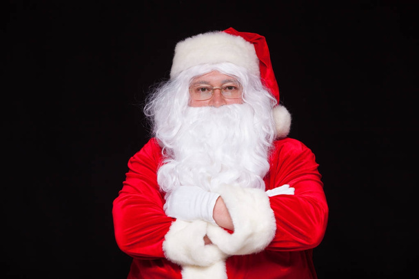 Christmas. Santa Claus portrait smiling against black background. - Фото, изображение