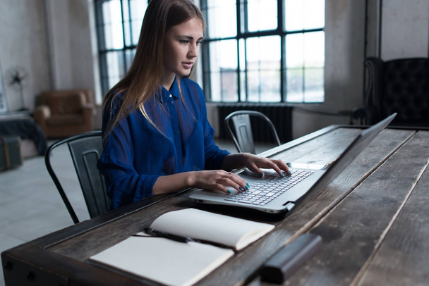 Mujer con las manos en el teclado del portátil. Diseñador sentado en la mesa de trabajo con portátil y computadora en él
. - Foto, imagen