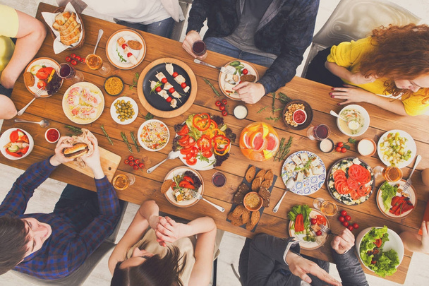 People eat healthy meals and talk at served table dinner party - Фото, изображение