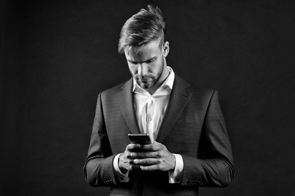 Manager with beard on serious face hold phone. - Foto, afbeelding