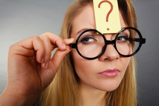 Woman having question mark on forehead thinking - Photo, image
