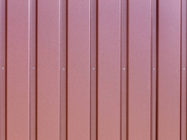 Vöröses-barna acél trapézlemezzel fedtek be a függőleges segédvonalak. - Fotó, kép