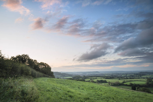 wunderschöne Landschaft im Morgengrauen über Purzelbäumen in englischem Land - Foto, Bild