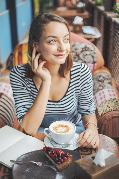 νεαρή γυναίκα που κάθεται εσωτερικούς χώρους στα αστικά café - Φωτογραφία, εικόνα