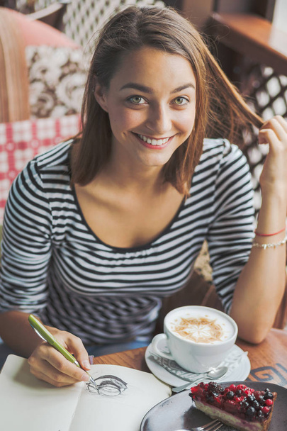 Mujer joven sentada en el interior de un café urbano
 - Foto, imagen