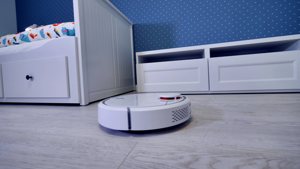 A robotic vacuum cleaner starts its routine from the door. - Footage, Video