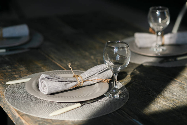 Tablo ayarı. Çift gri tabak boş. Bıçak ve çatal. Eski moda şarap bardağım. Rustik peçete. Ahşap masa. Seçici odak - Fotoğraf, Görsel