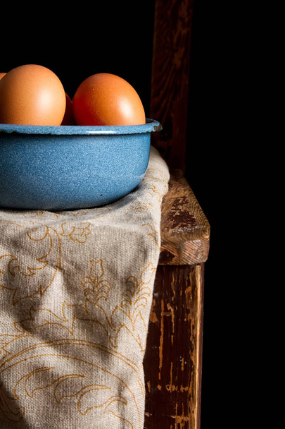 Eggs in a plate. Chicken farm. Dark background. - Foto, afbeelding