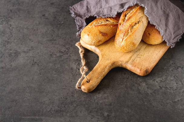Homemade Italian bread. Fresh bakery. Dark background. - 写真・画像