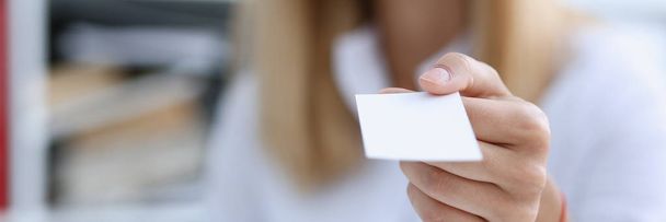 Femme d'affaires souriante tenant la main en chemise blanche donner carte de visite vierge
 - Photo, image
