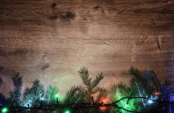 Nieuwjaar elektrische garland op een houten achtergrond. Heldere bollen o - Foto, afbeelding