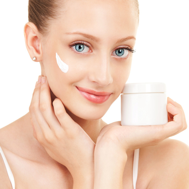 Cute woman applying cream to her face - Zdjęcie, obraz