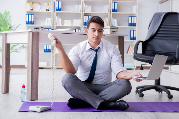 Mies meditoi toimistossa selviytyäkseen stressistä - Valokuva, kuva