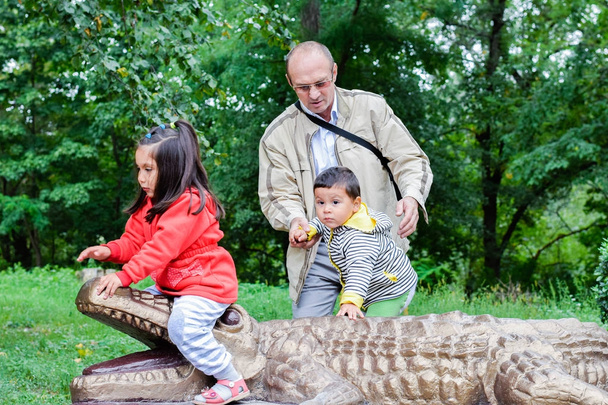 Glücklicher Opa und kleine Enkel spielen im Zoo.  - Foto, Bild