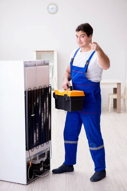 Reparateur aannemer repareert koelkast in DIY concept - Foto, afbeelding