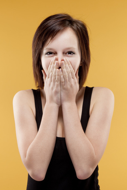adolescente sorprendida cubriendo la boca con sus manos
 - Foto, Imagen
